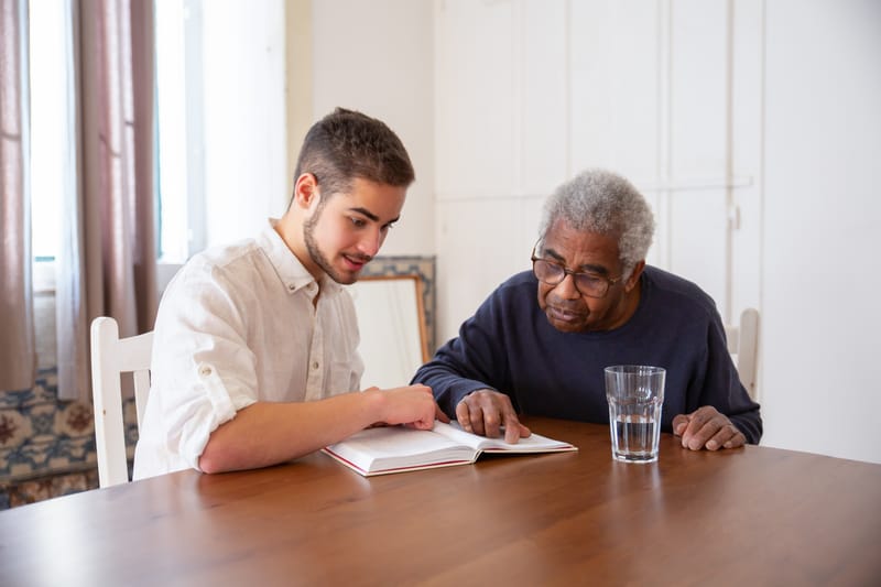Caregiver helping elderly man with personal care